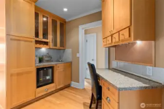 The wet bar is complete with a wine refrigerator and additional stainless steel sink. The built-in desk with the granite countertop is practical and inviting for day-to-day living.