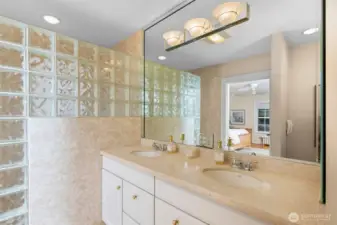 Primary en-suite features an oversized marble walk-in shower, marble floors and countertops plus dual sinks and ample storage space (not shown in photo).