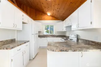 Kitchen is freshly painted and has new countertops, vaulted wood ceiling.