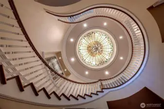 Hand painted backlit art dome is featured at the top of the staircase