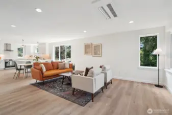 Photos of staged unit, 20313A. Floor plans are identical. Expansive living room with LVP flooring and ceiling mounted high efficiency heating and cooling mini-split system