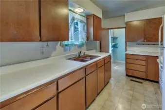 Retro charm meets functionality in this galley-style kitchen—offering tons of cabinet space, ample counters, and a cozy window view over the sink