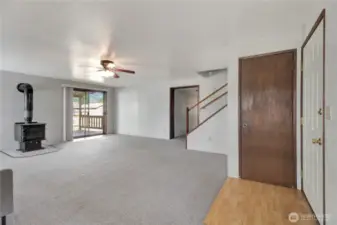 Corner view of living room. Coat storage and wood stove.