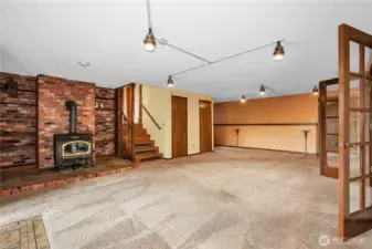 View of family room from the office, has wood burning fireplace, first door is a closet, the second door on the right is a closet with the  laundry shoot.