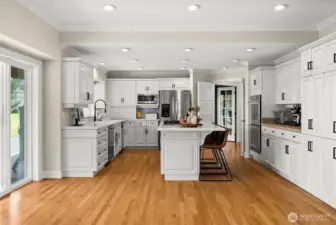 Chef's kitchen features new hardware and stainless steel appliances. Quartz countertops paired with tile countertops for the appliance bar.