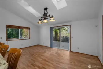 Dining room with vaulted ceilings and skylights. Sliding door leads to huge, wraparound deck.