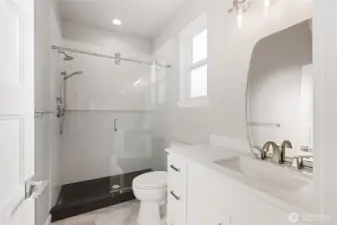 The downstairs primary bathroom features under cabinet lighting, solid one piece quartz slab shower, with a solid one piece quartz pan! This is a very rare feature, making the shower a seamless beauty that is easy to clean and maintain! Tile floor throughout.