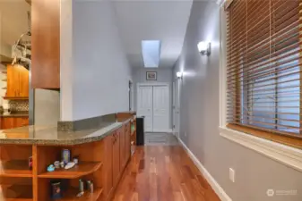 Hallway from front door, leads to laundry room, storage and the garage.