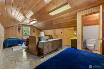 Spacious Bunk Room with Half Bath  The upstairs loft offers plenty of room for guests or kids, featuring a half bath and charming angled ceilings. Built-in storage in the attic eaves keeps things tidy while maximizing space.
