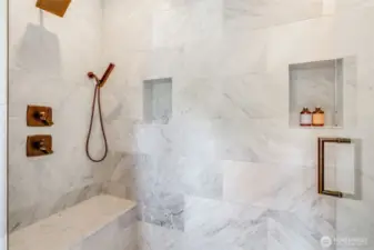 Luxurious walk-in shower with Carrara marble, heated floor, three shower heads, product shelves and a shower seat. Great place to start your day!