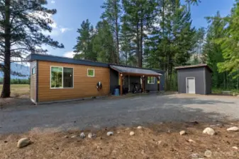 Graveled driveway, covered entry, and storage shed—simple, functional, and fire-wise.