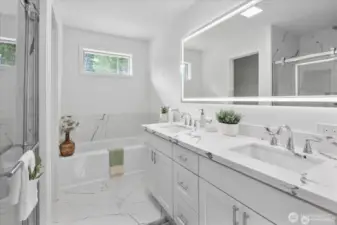 Spa like bathroom in the primary bedroom, with custom tile, quartz counters and LED mirror.