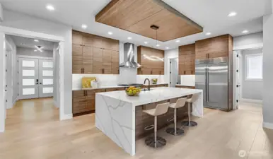 Enviable gourmet kitchen boasts 48" Subzero Refrigerator, Wolf Double-Oven, 6-Burner & Griddle Range, 48" Zephyr Pro Hood, Cove Dishwasher, Sharp Microwave Drawer, and anchored by an oversized quartz island.