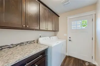 Laundry room with cabinet storage and granite counter. Washer and dryer stay!