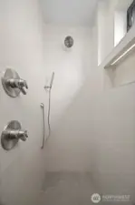 The stone tiled shower is an absolute work of art.