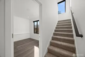 The carpeted stairway leads to the second bedroom and other open spaces that can be used as "dorm sleeping".