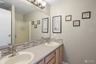 The Primary bath has double sinks in a large vanity, and a walk-in shower.