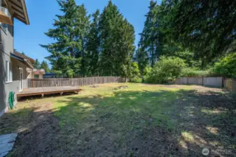 Fully fenced back yard with deck.