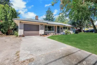 Welcome home! A charming and well-maintained façade with a fresh garage door, manicured garden beds, and a wide driveway offering ample parking. The inviting front entry and mature landscaping create a warm first impression