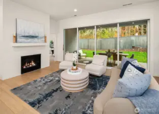 Great room with floor to ceiling tile fireplace and multi-stack doors open to covered patio