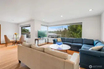 Generous living room with a wood-burning fireplace, newly refinished hardwood floors, and picture windows that frame the view