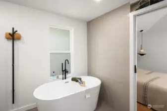 The beautifully appointed bathroom, complete with a soaking tub and a walk-in shower, offer a sanctuary of relaxation and rejuvenation.