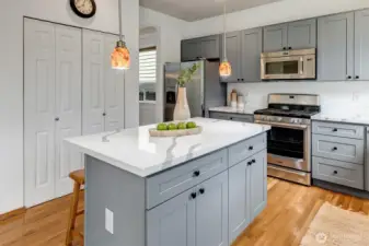 The sunny kitchen features a large island with bar seating, and a kitchen pantry.