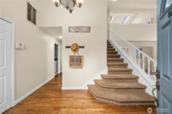 Hardwood floors complete the entry way, hallway and take you to the kitchen just ahead.  The staircase invites you to the loft and bedrooms above.