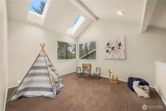 The loft continues the high vaulted ceilings with a flood of light from the upper windows.