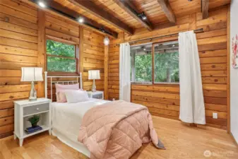 Main level guest suite highlighted by warm timber-lined walls.