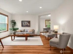 Sunlit living room with large front windows illuminating light throughout