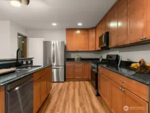 Ample kitchen cabinet space and sleek new kitchen appliances include new range, microwave, refrigerator, and dishwasher