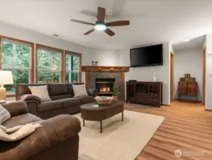 Gas Fireplace, ceiling fan and wood-like flooring create a cozy atmosphere in spacious great room