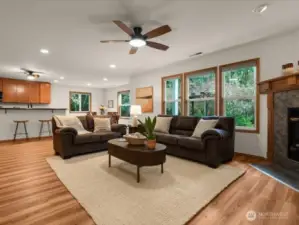 Spacious great room adjoins kitchen with cozy gas fireplace and a stunning window wall, that frame tranquil views of the landscaped backyard and lush greenbelt