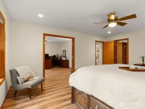 Wood-like flooring sprawls from primary suite into private office behind double doors offering a cohesive feel