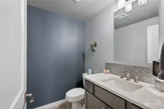 Main floor powder room with a lovely feature wall.