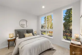 Bright and airy, this secondary bedroom offers oversized windows and a peaceful view, perfect for unwinding after a long day.