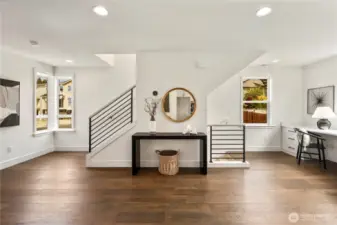 Wide angle shot of the light and bright main living areas, including the built-in desk area and the stairs going both up and down.