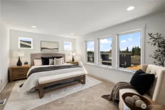 Upper level primary bedroom with attached ensuite bathroom and sitting area
