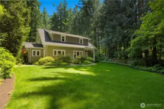 This view highlights the level backyard and professional landscaping which includes a multi-zone sprinkler system.