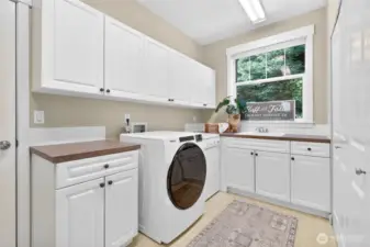 Large laundry room with plenty of storage and utility sink