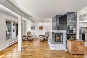 Looking into second half of the large main living space, this cozy fireplace compliments the area so well!
