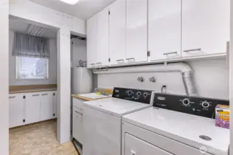 Extra large utility room with tons of extra storage space, additional counter space and wash basin style sink.
