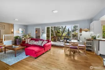 Bright, open living area with large windows, hardwood floors, and seamless flow into the dining space. Perfect for entertaining.