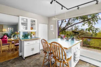 Charming breakfast nook surrounded by windows, offering beautiful views while you enjoy your morning coffee.