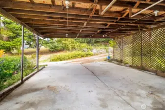 Covered carport provides convenient parking and protection from the elements.