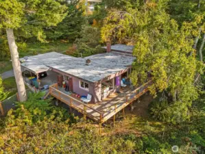 Aerial view of the home tucked into a peaceful wooded setting.