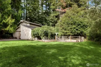 Charming barn surrounded by evergreens — a serene retreat for hobby farming or equestrian use.