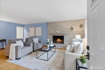 Open concept living to dining room space allows for easy entertaining while enjoying views from the picture windows in front of the wood burning fireplace.