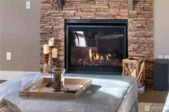 Stylish gas fireplace with stacked stone surround and warm ambiance